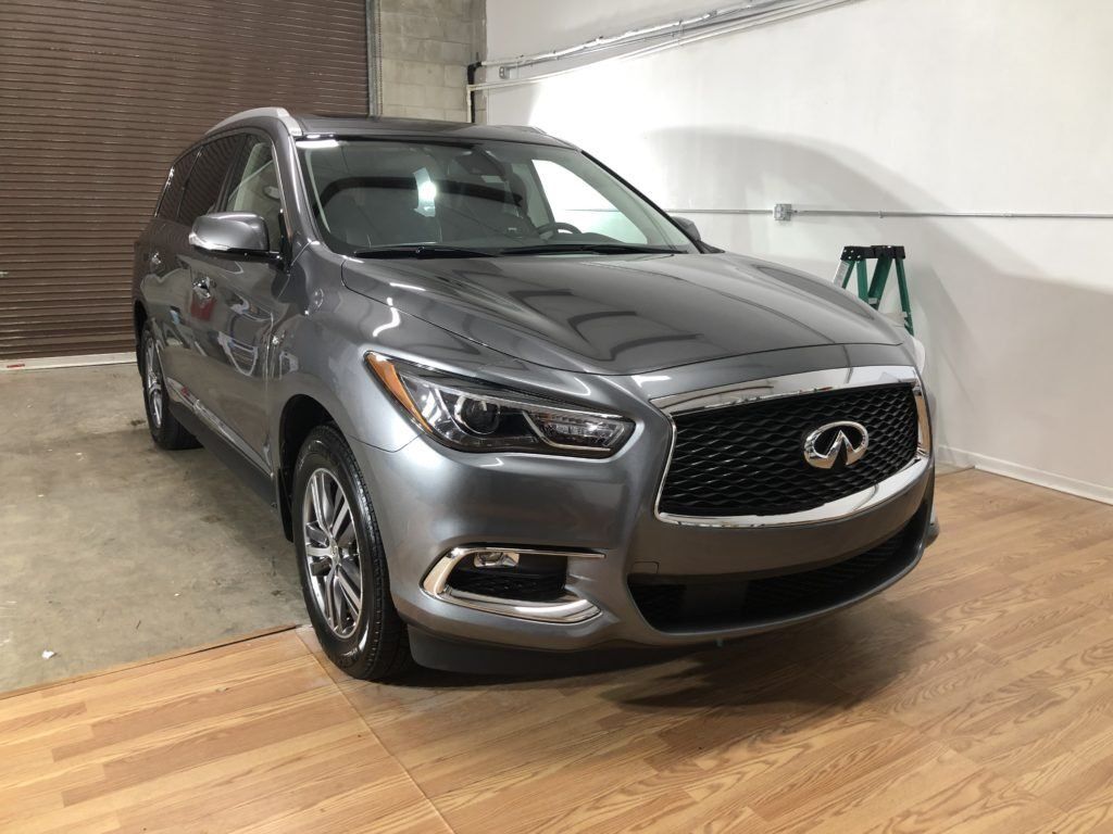 A gray infiniti q50 is parked in a garage.