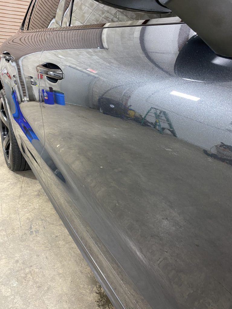 A close up of a car door in a garage.