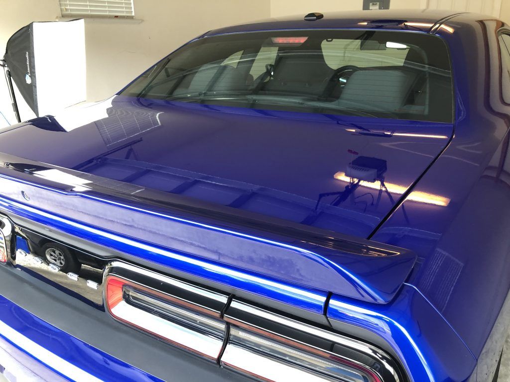 A blue dodge challenger is parked in a garage.