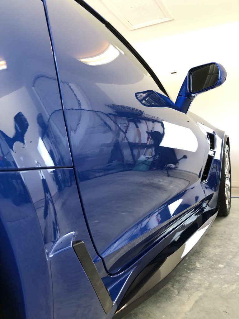 A blue sports car is parked in a garage.
