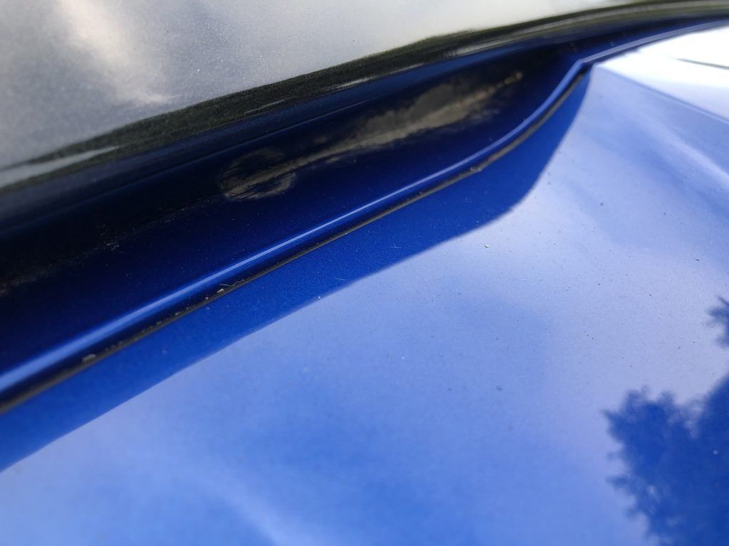 A close up of a blue car with a black trim