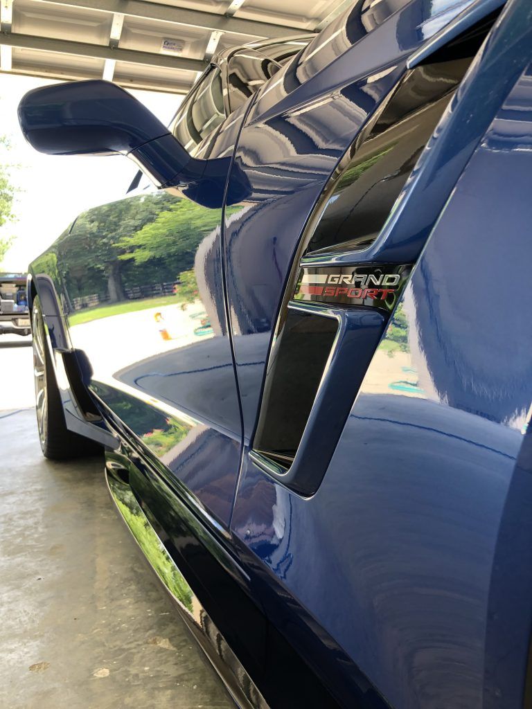 A blue sports car is parked in a garage.