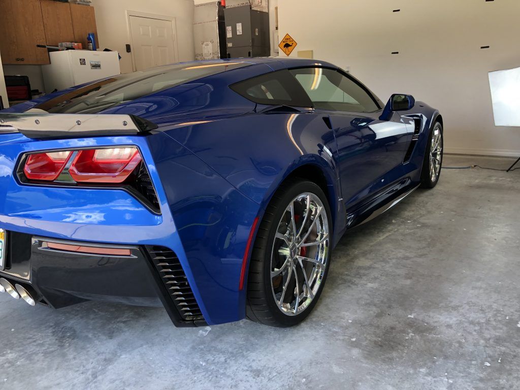A blue sports car is parked in a garage.