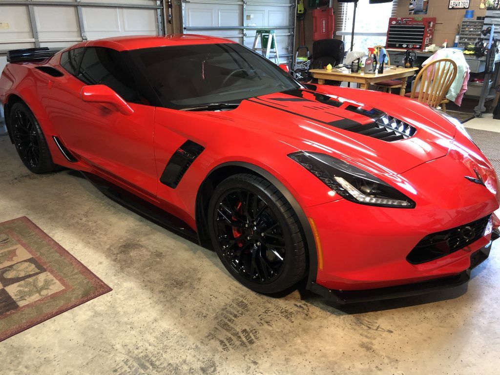 A red corvette zr1 is parked in a garage.