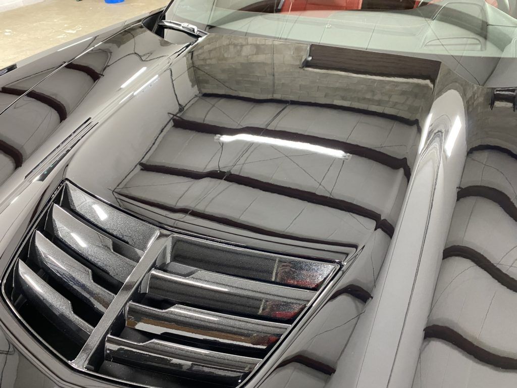 The hood of a car is reflected in a mirror