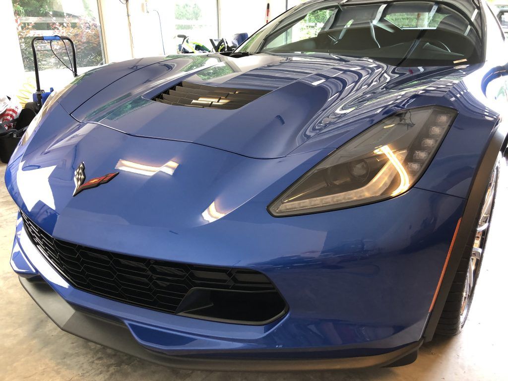 A blue sports car is parked in a garage.