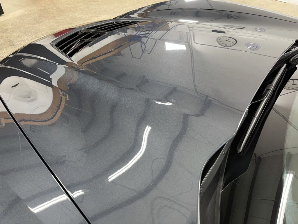 A close up of the hood of a car in a garage.