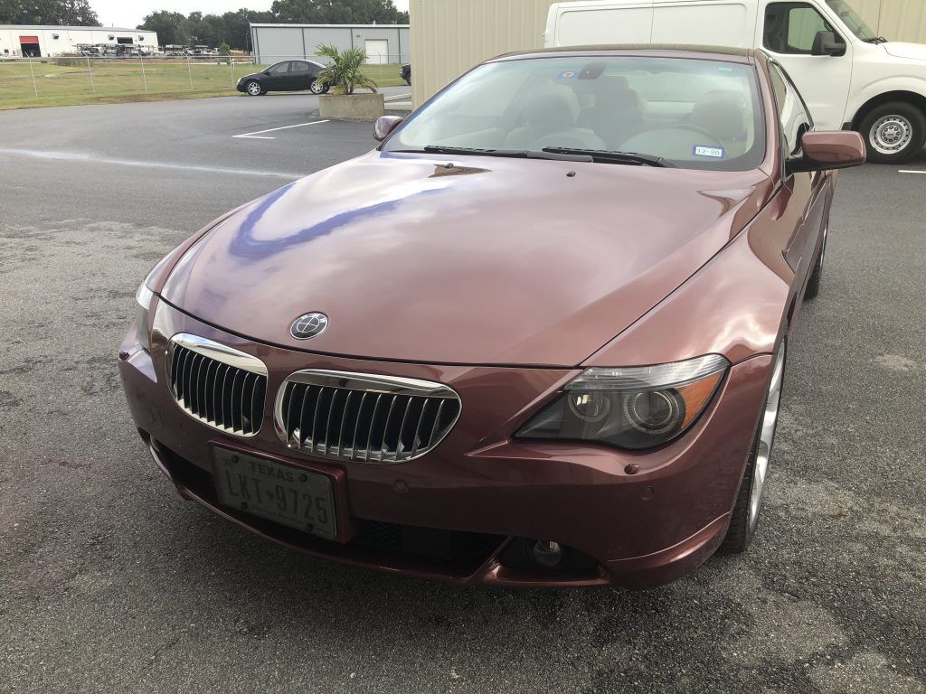 A brown bmw is parked in a parking lot.