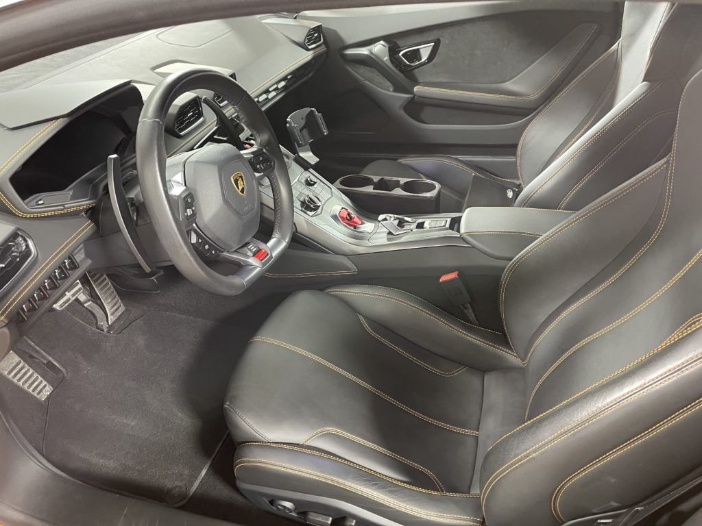 The interior of a car with black leather seats and a steering wheel.
