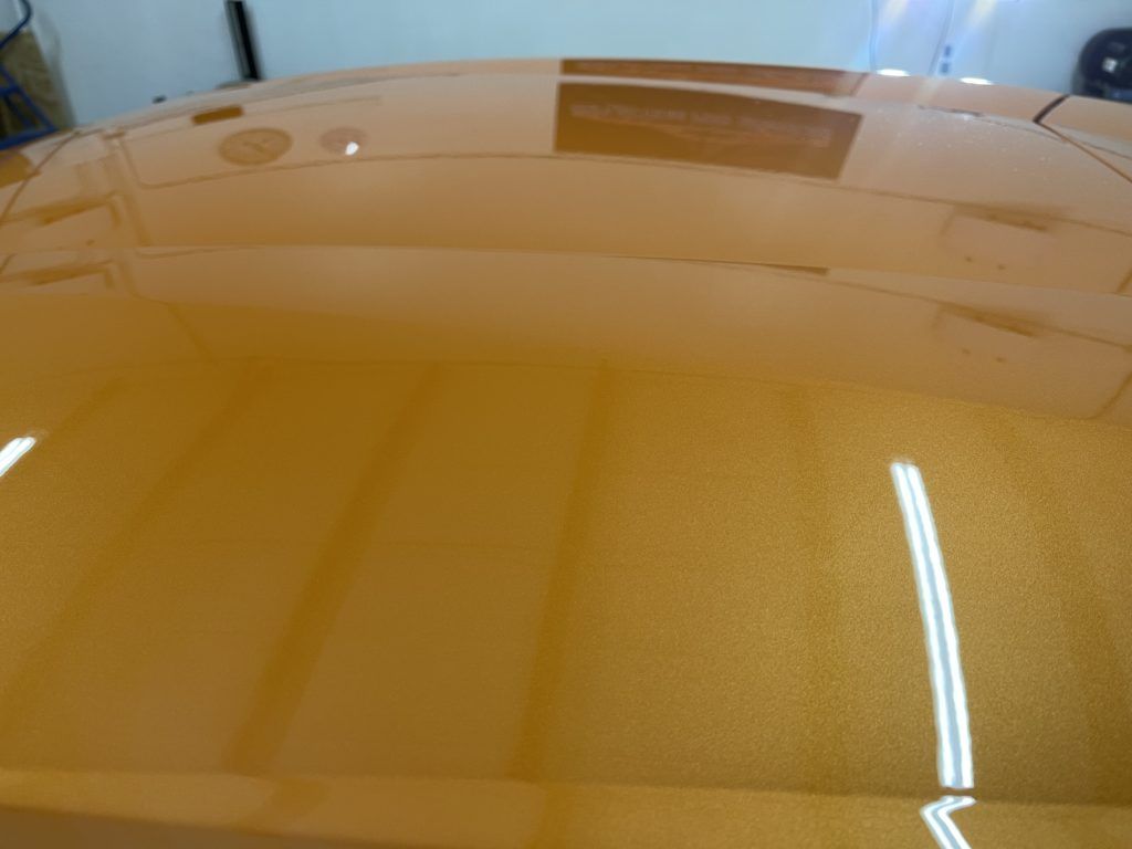 A close up of a car 's hood in a garage