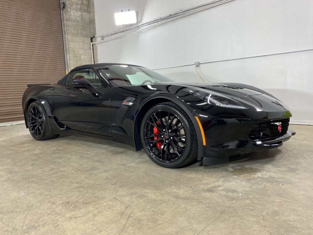 A black corvette zr1 is parked in a garage.