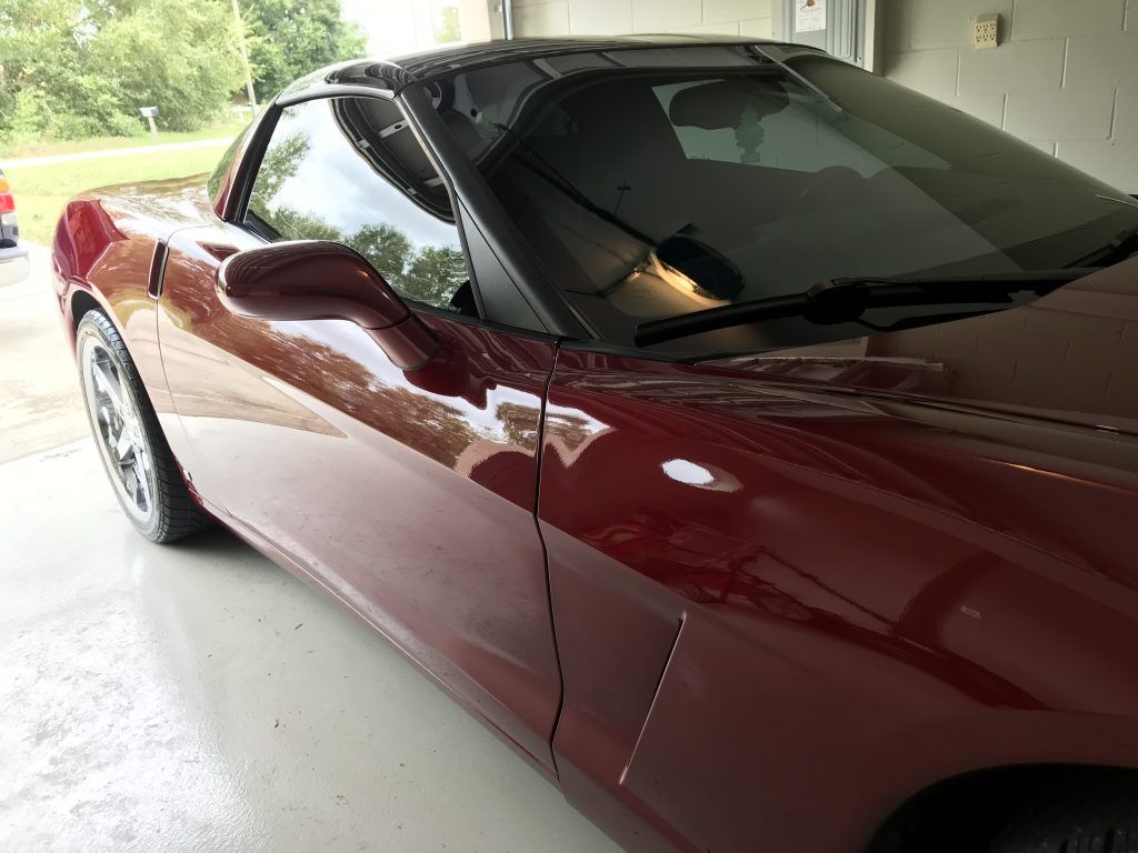 A red sports car is parked in a garage.