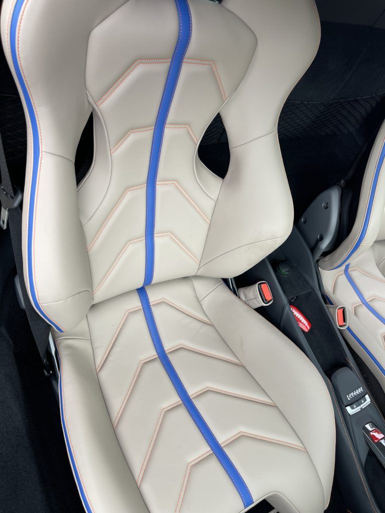 A close up of a car seat with a blue stripe on it.