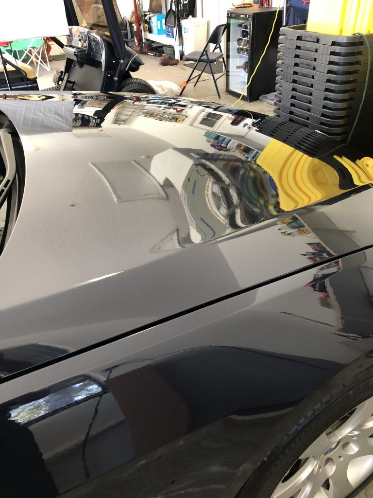 A close up of a car 's hood in a garage.