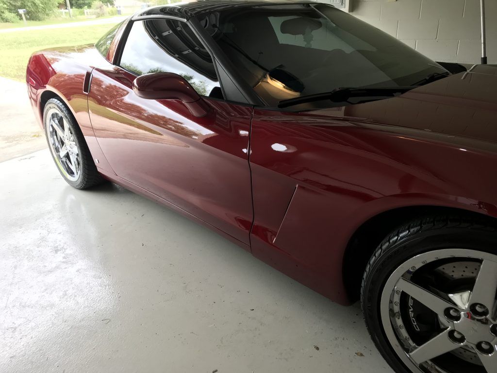 A red sports car is parked in a garage.