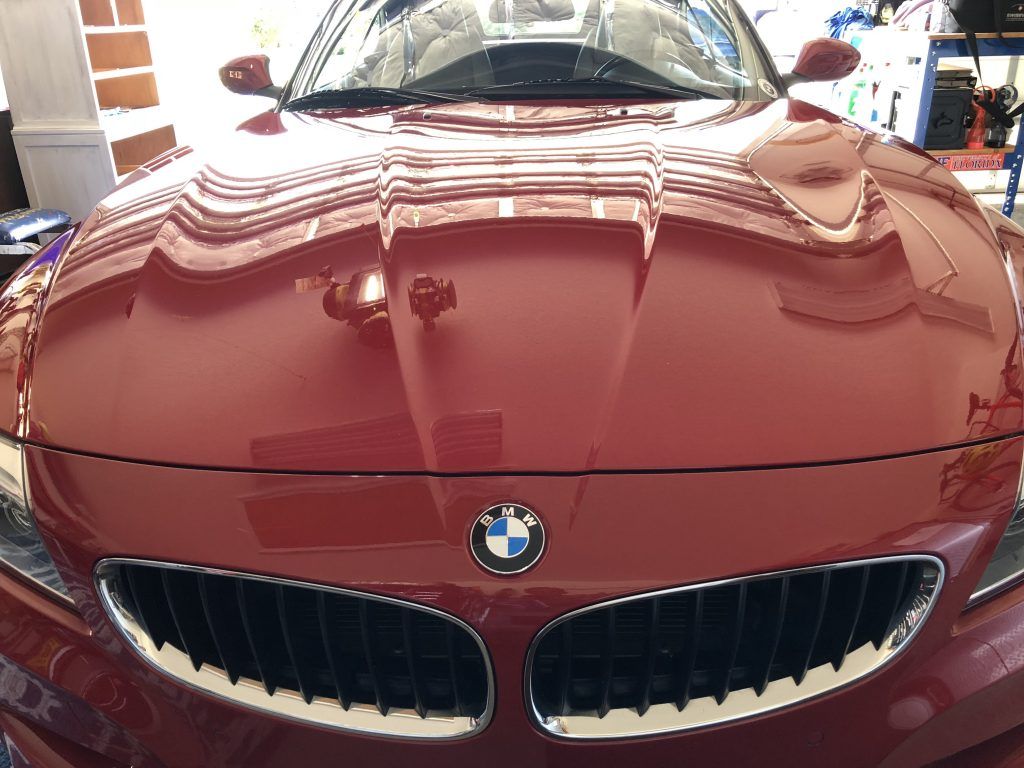 A red bmw is parked in a garage.