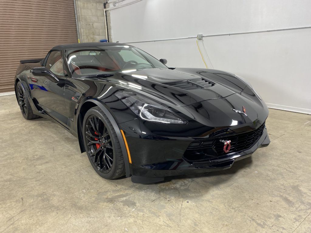 A black corvette zr1 is parked in a garage.