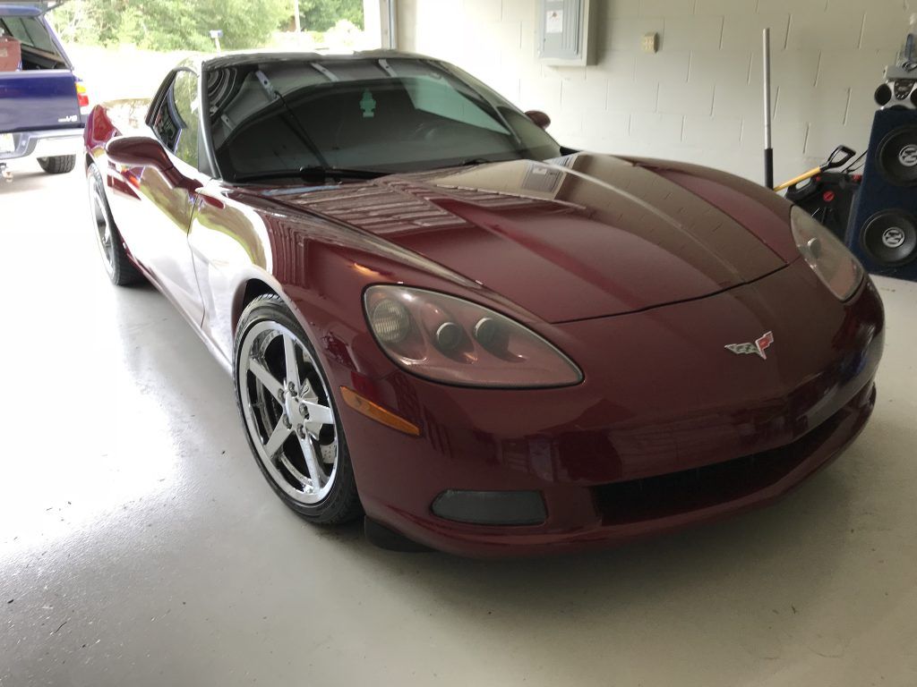 A red sports car is parked in a garage.