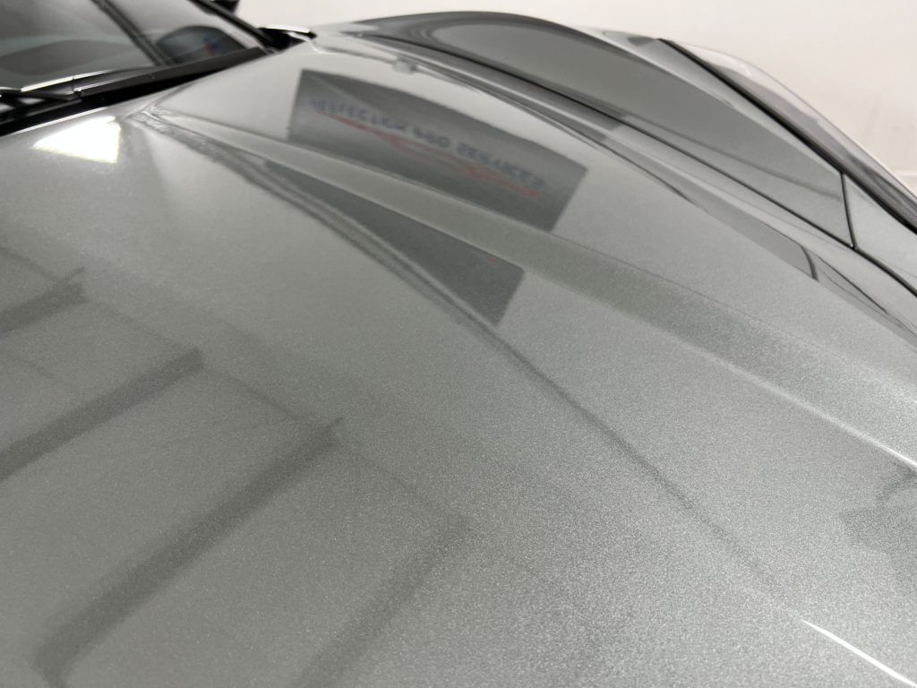 A close up of the hood of a silver car