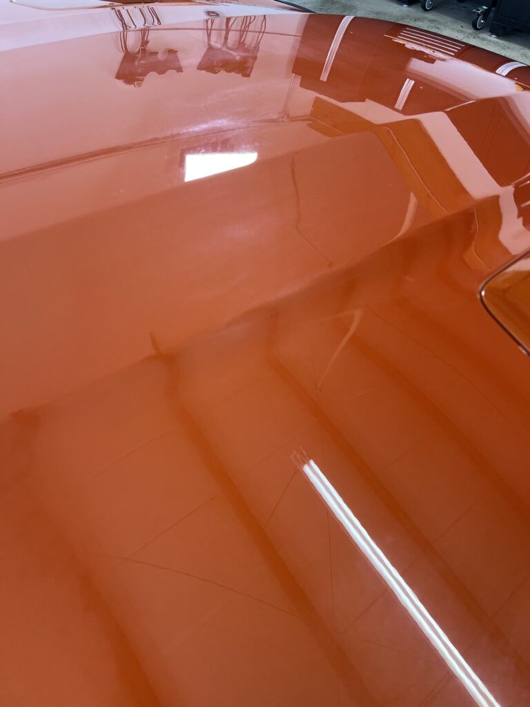 A close up of the hood of a car in a garage.