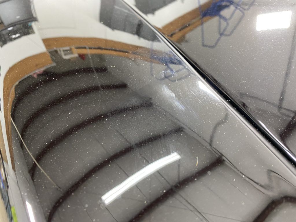 A close up of a car 's hood in a garage.