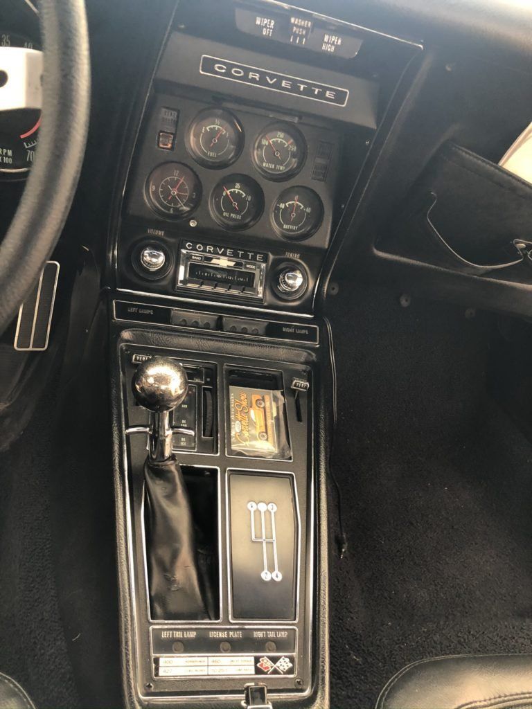 A corvette dashboard with a shifter and a steering wheel