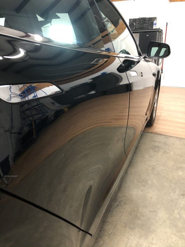 A black car is parked in a garage.