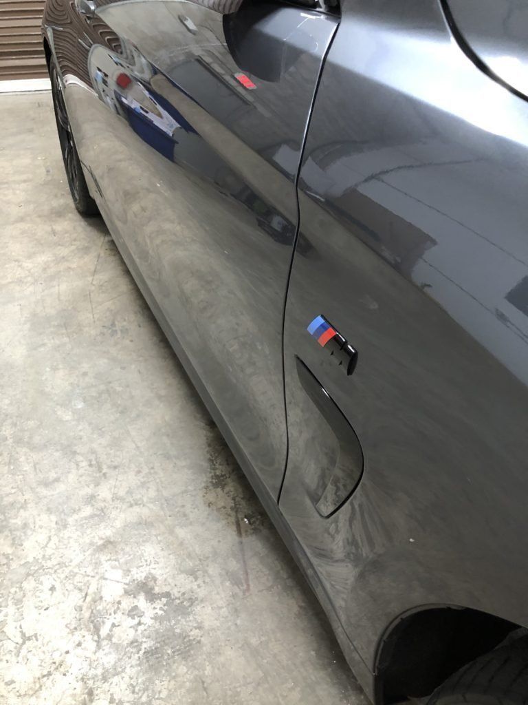 A close up of a black car parked in a garage.