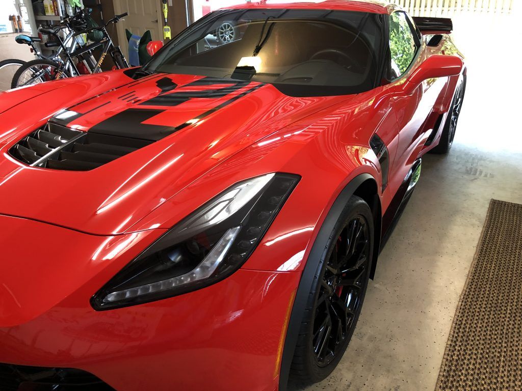 A red sports car is parked in a garage.