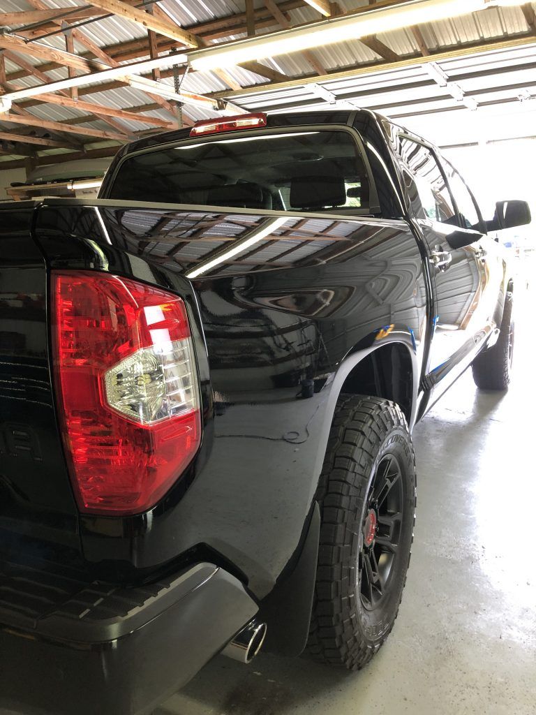 A black toyota tundra is parked in a garage.