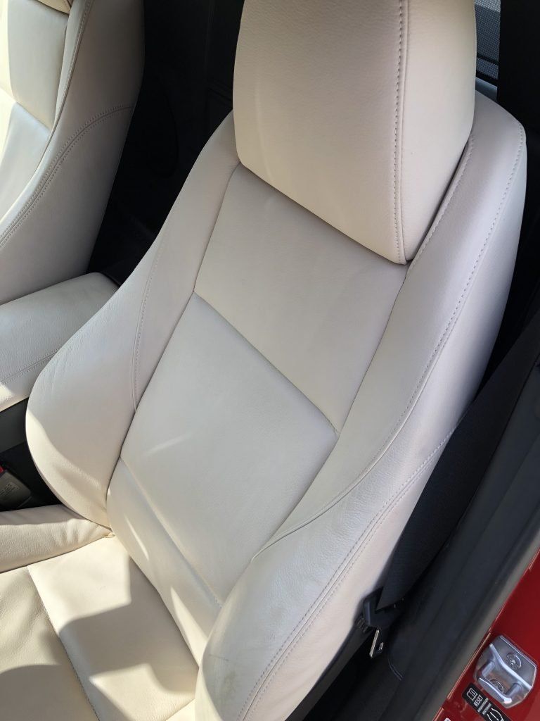 A close up of a white leather seat in a car