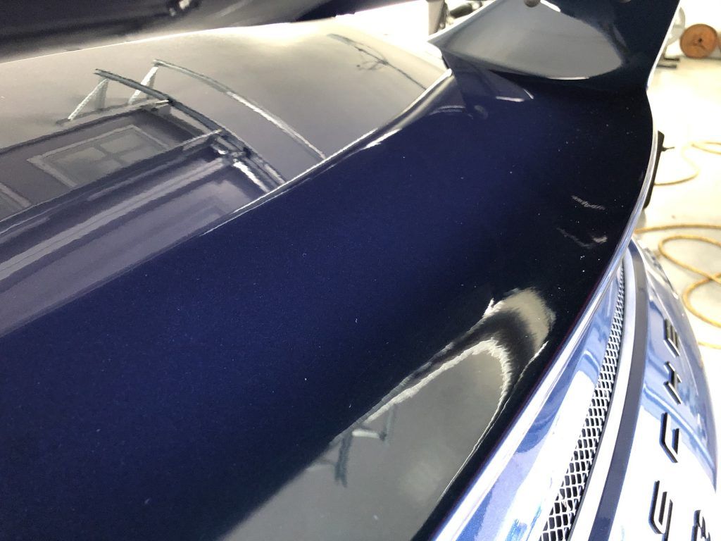 A close up of the hood of a blue car