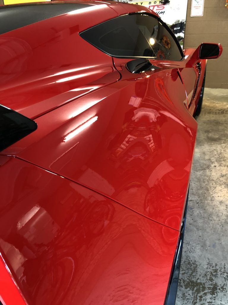 A red sports car is parked in a garage.
