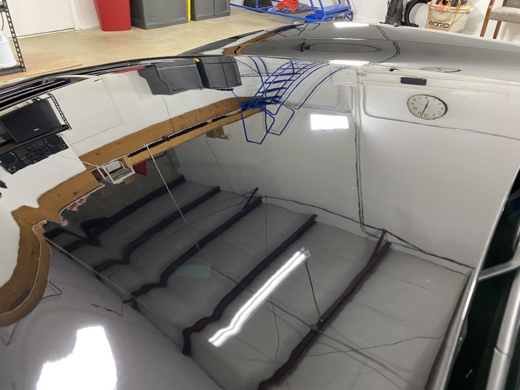 The roof of a car is reflected in a mirror.