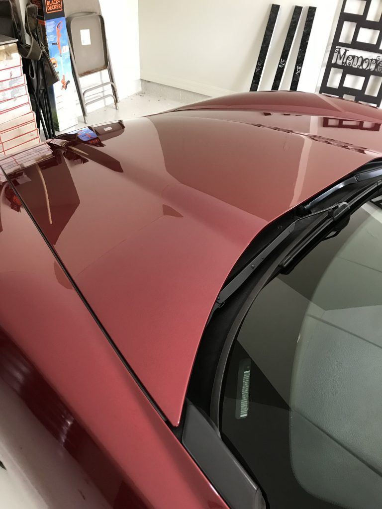 A red sports car is parked in a garage.