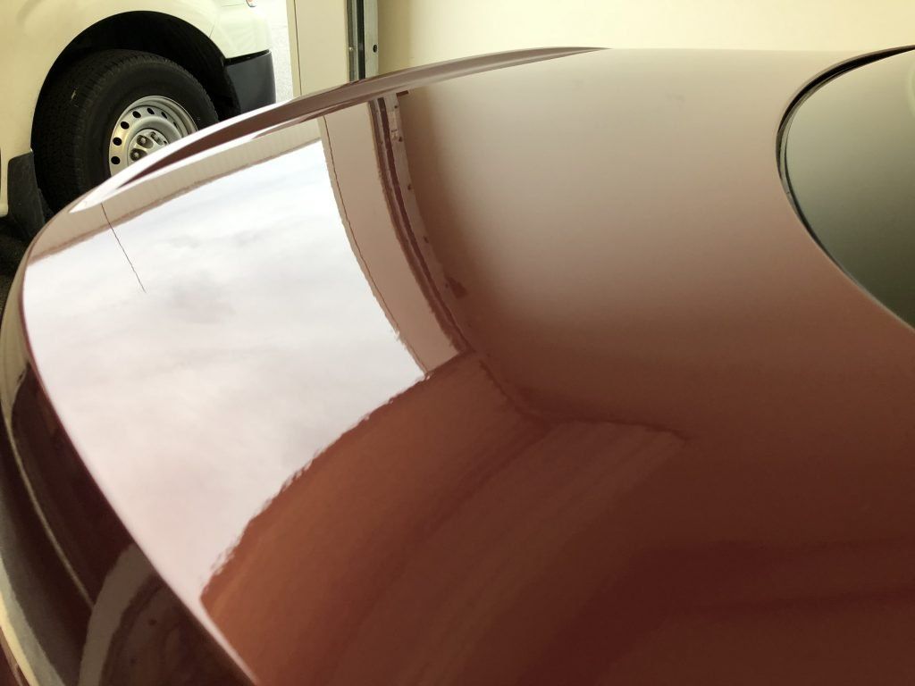 A close up of a car 's hood in a garage