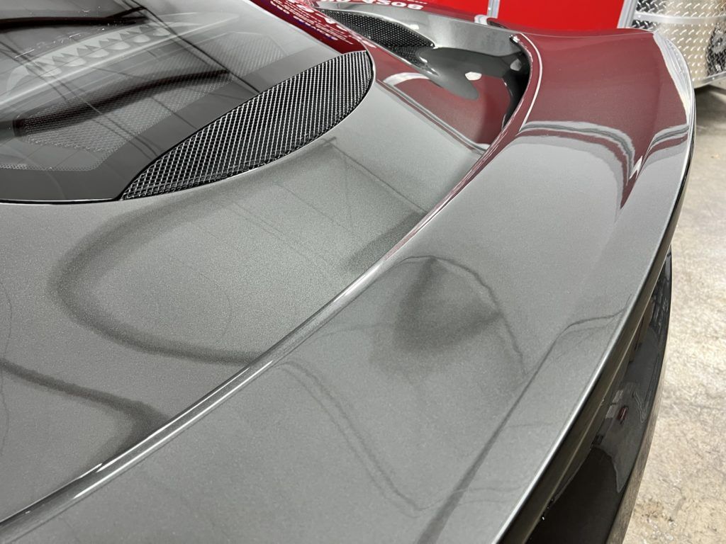 A close up of the rear end of a car in a garage.