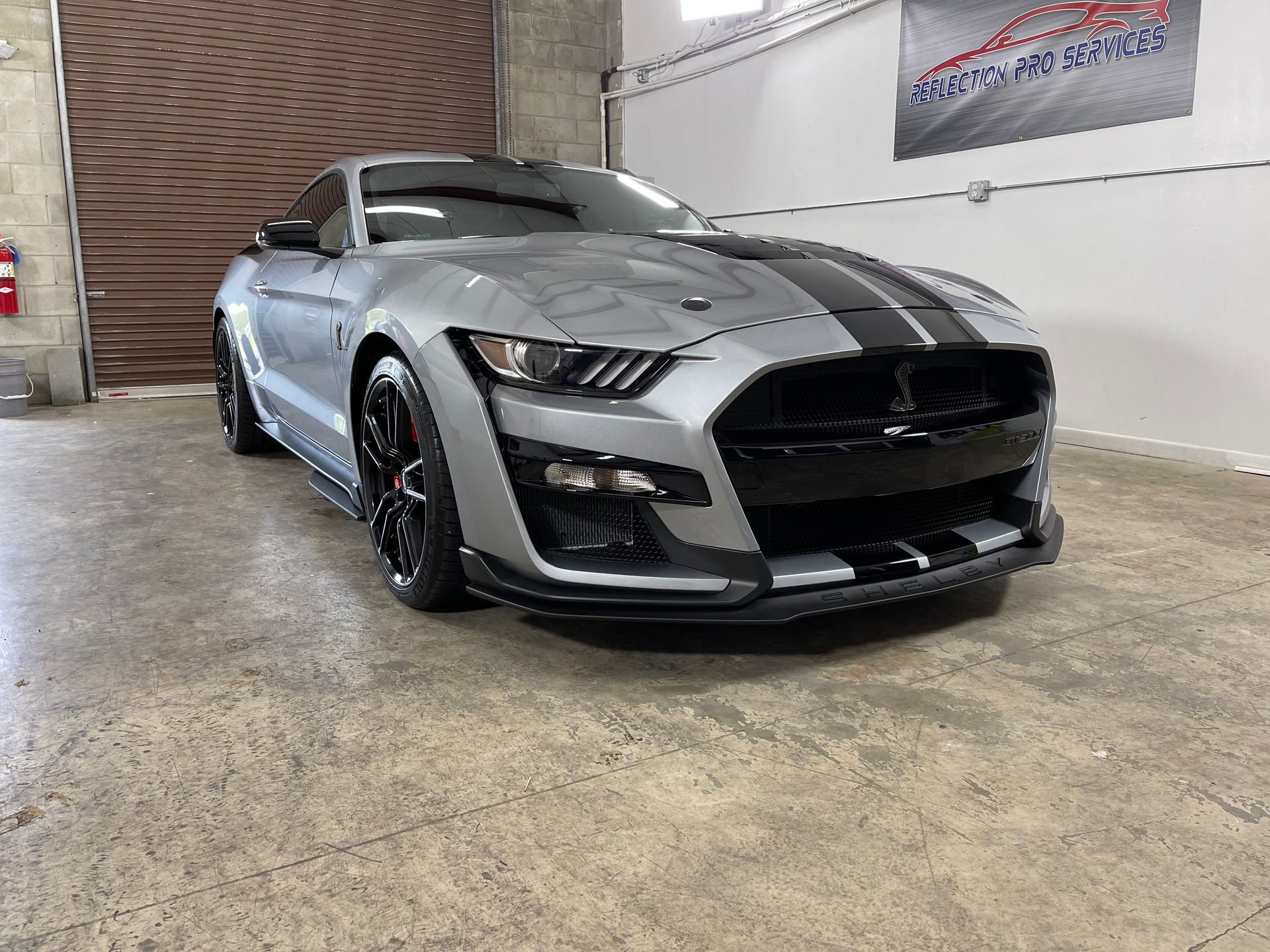 A gray lamborghini aventador is parked on the side of the road.