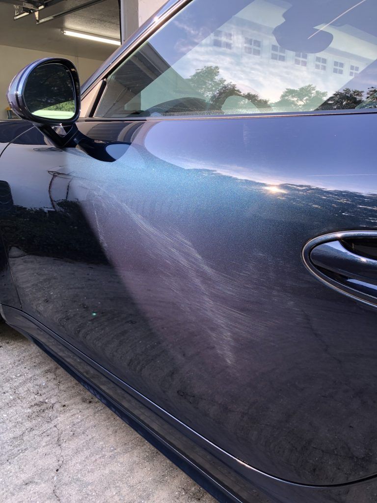 A close up of a blue car parked in a garage.