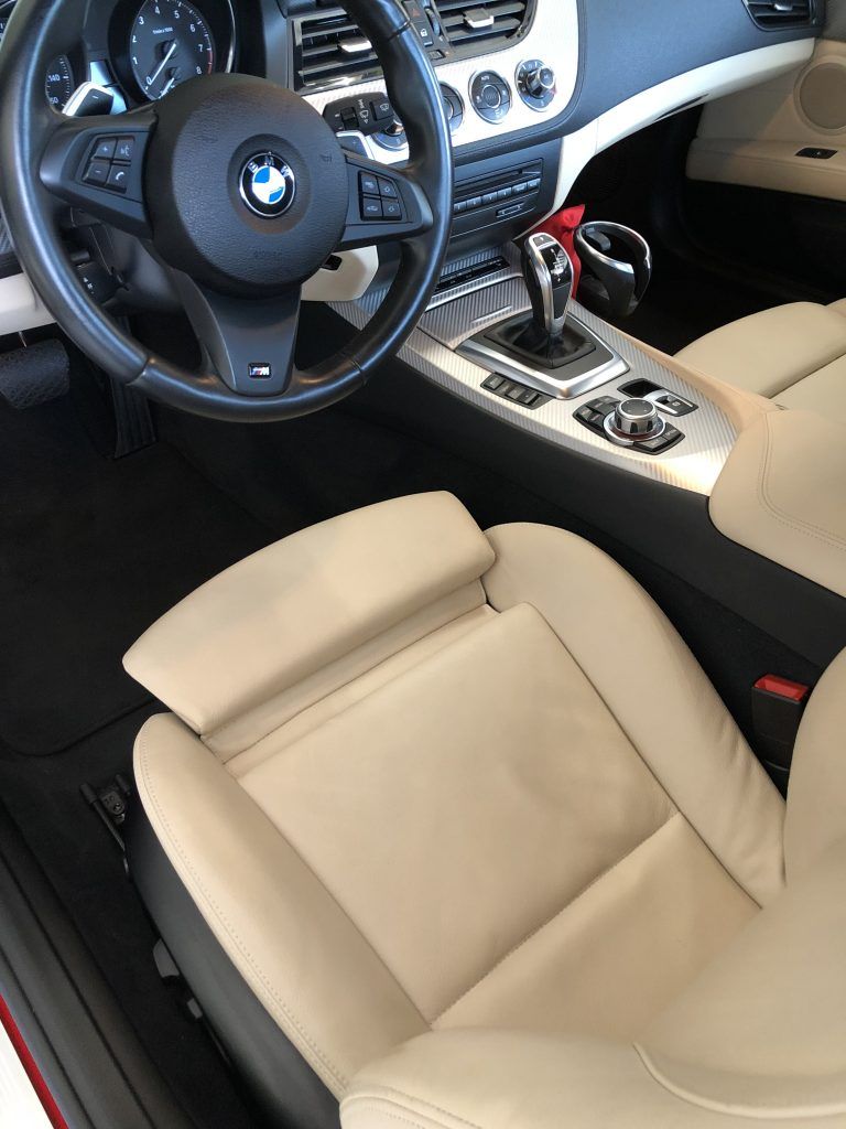 The interior of a bmw with tan seats and a steering wheel