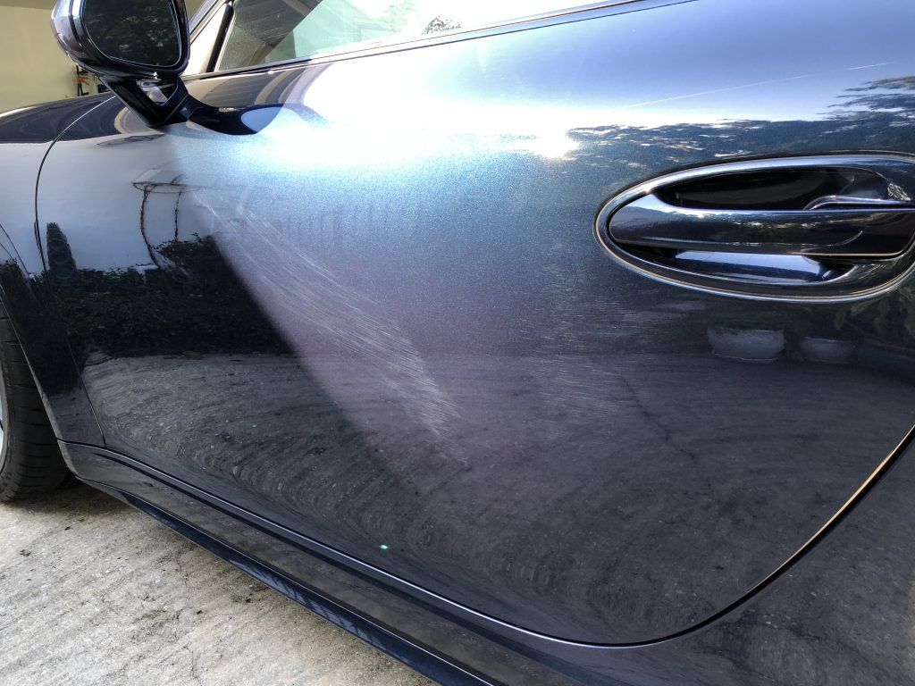A black car is parked on the side of the road.