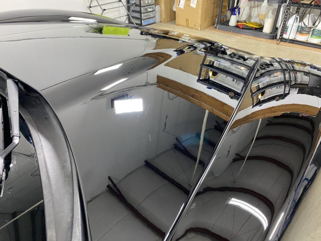 The roof of a car is reflected in a mirror.