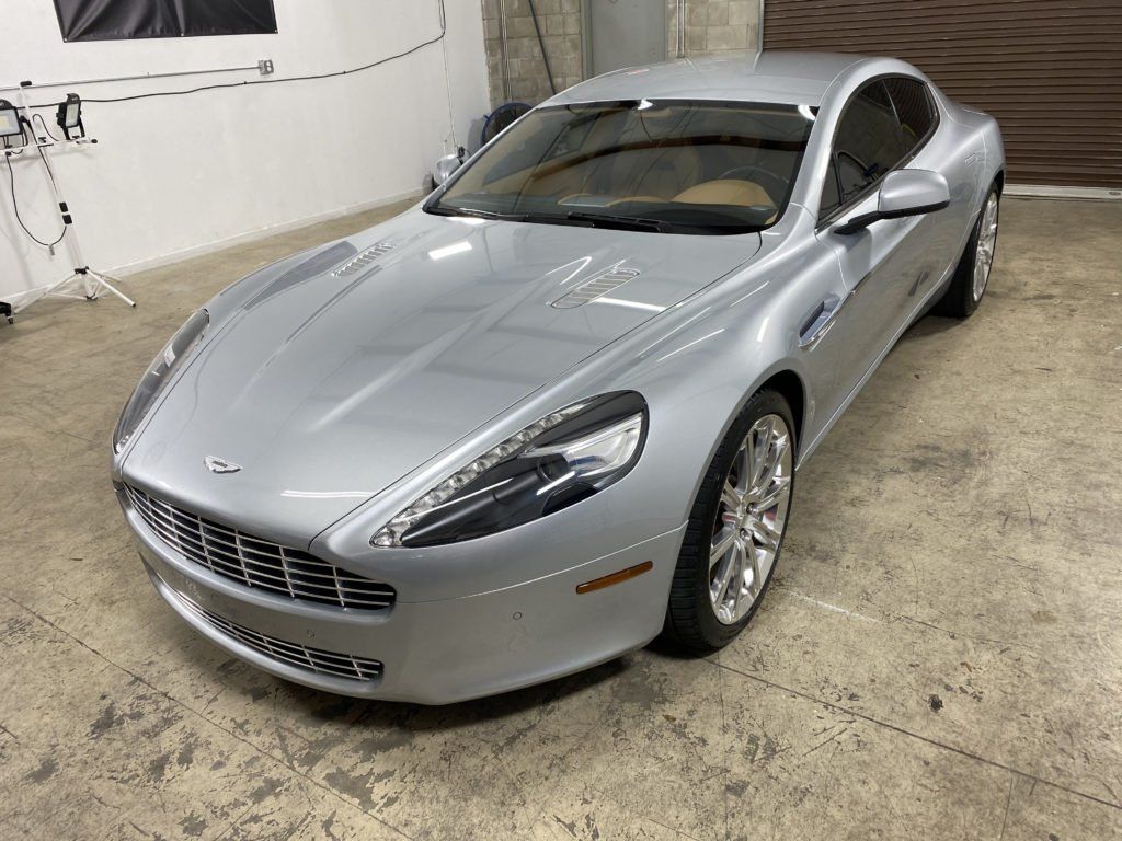 A silver sports car is parked in a garage.