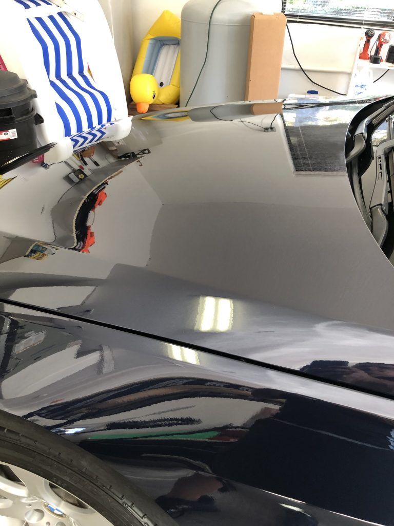 A close up of the hood of a car in a garage.