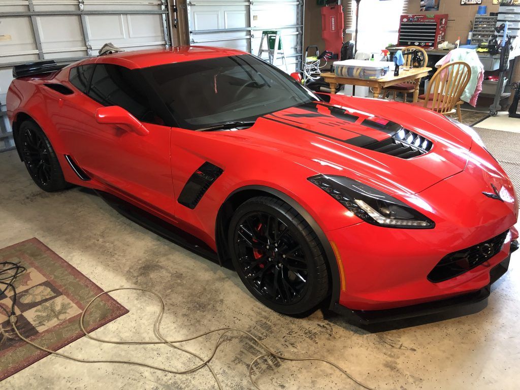 A red corvette zr1 is parked in a garage.