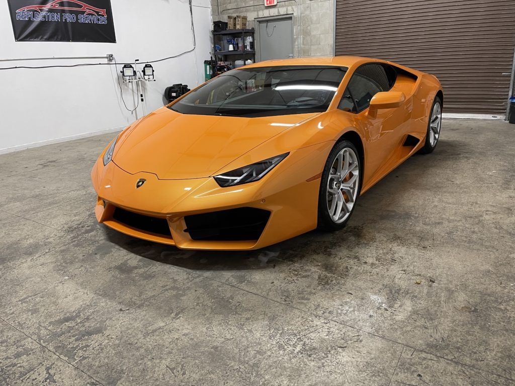 A yellow lamborghini huracan is parked in a garage.