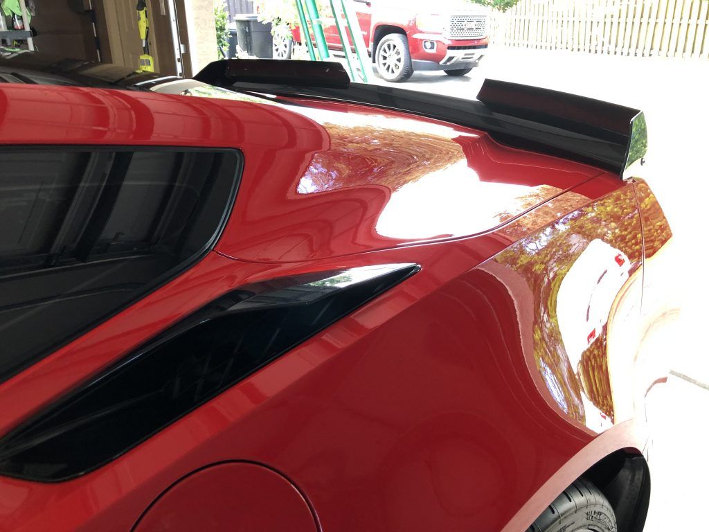 A red sports car is parked in a garage.
