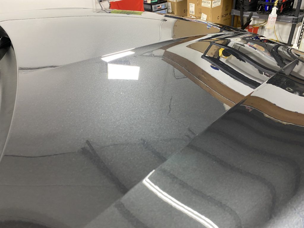 A close up of the hood of a car in a garage.