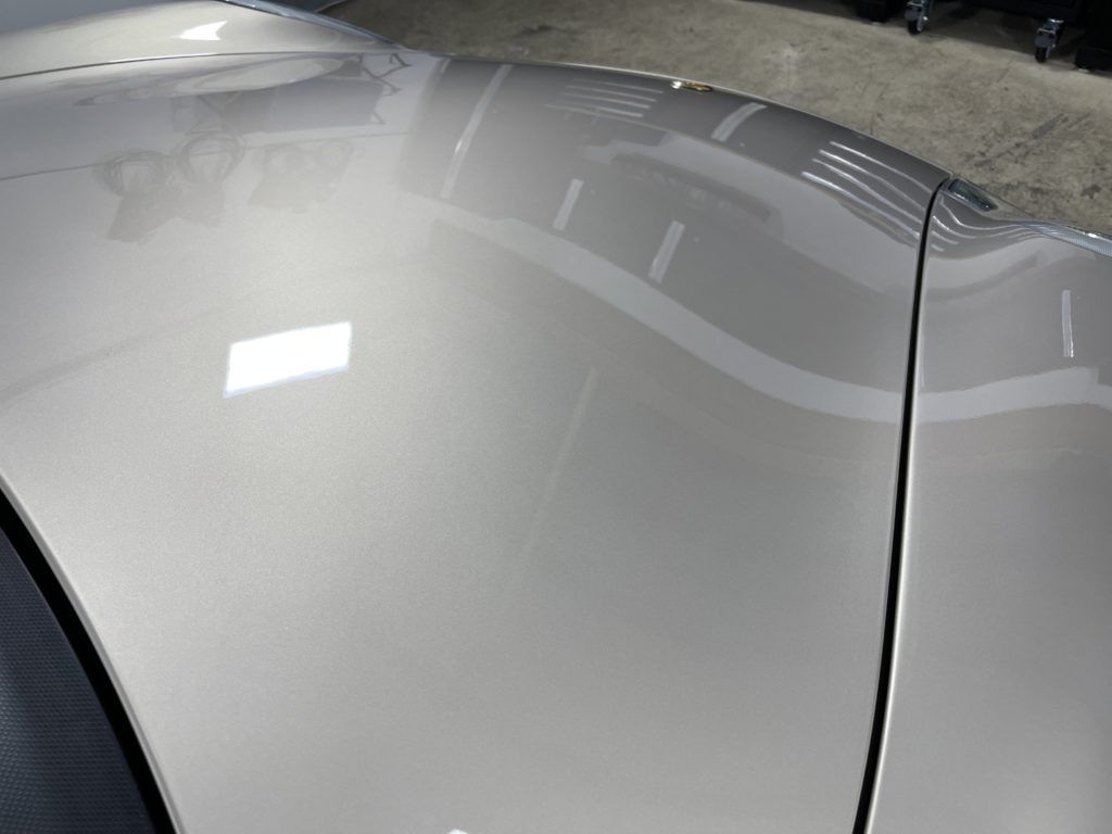 A close up of the hood of a silver car