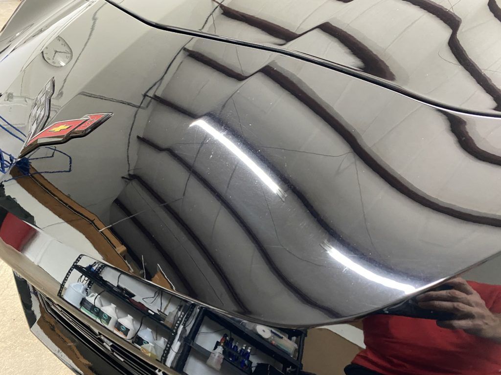 A person is taking a picture of a car in a mirror